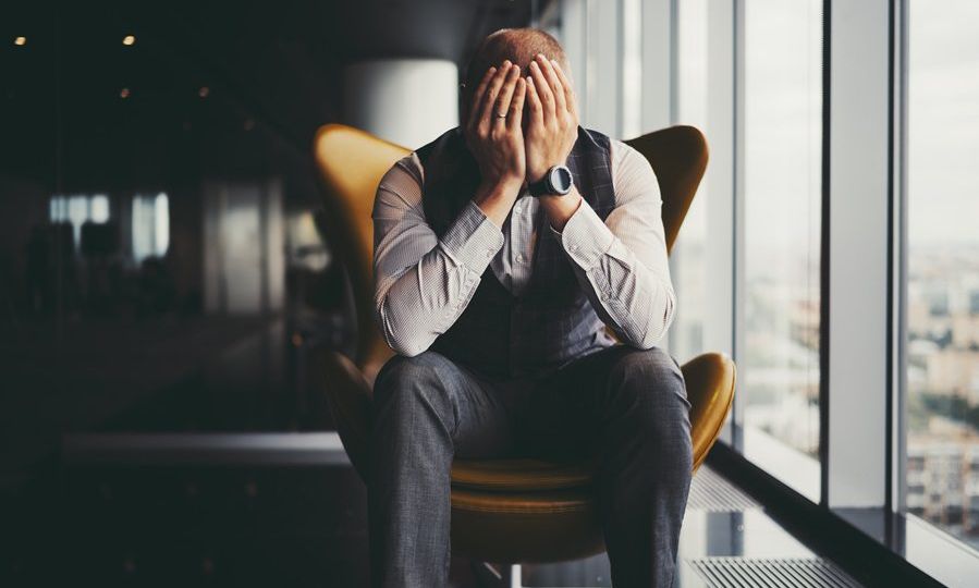 Frustrated businessman on armchair near window