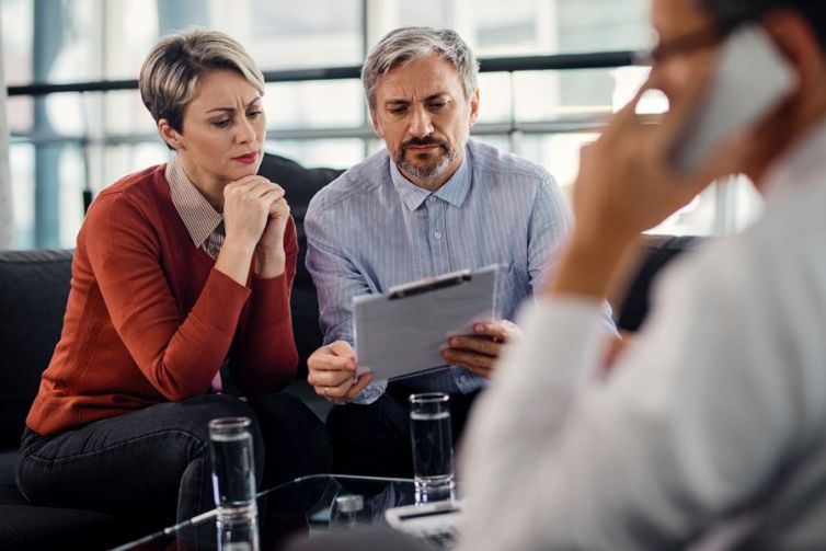 Suspicious couple going through insurance agreement while being